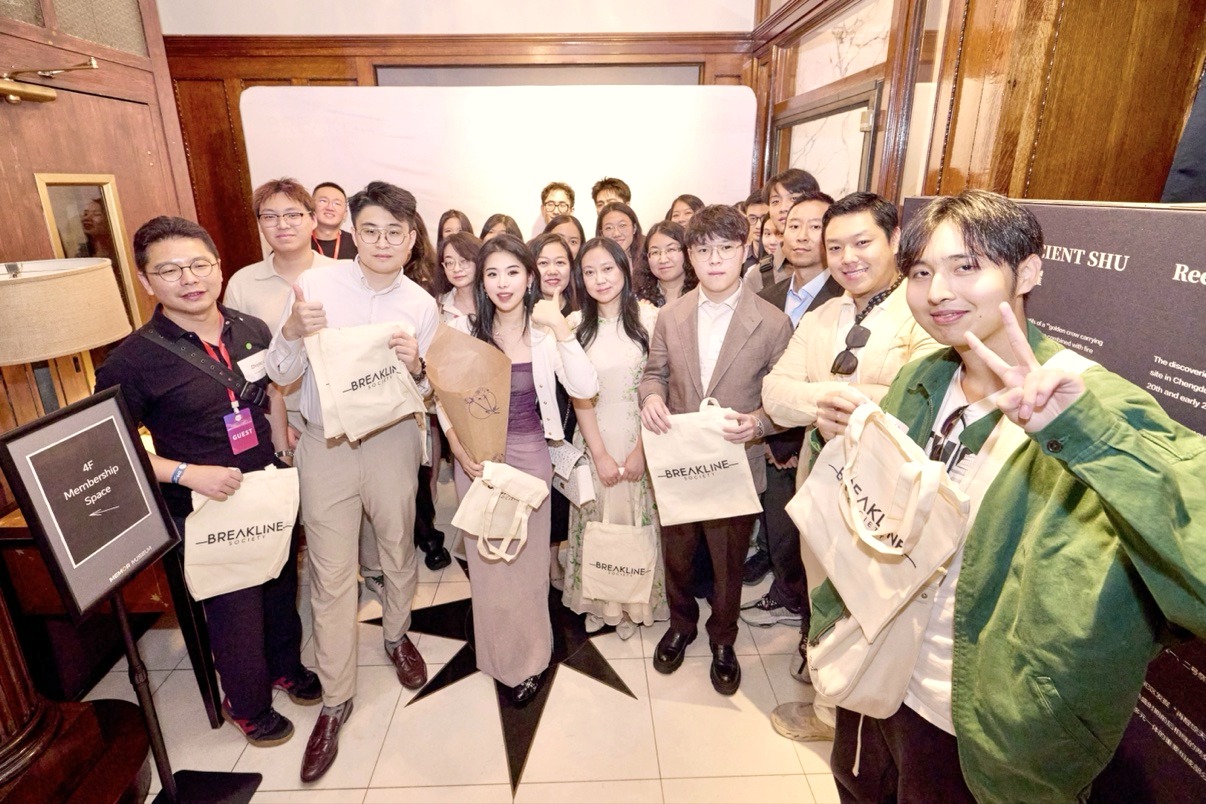 Breakline Society members holding BREAKLINE tote bags in a group photo at the FinTech Founders Roundtable, with founder Lucia Liu in a purple dress at the center