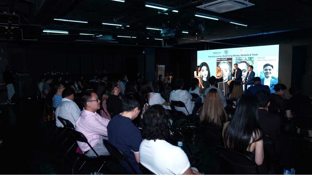 Audience watching the AI in Fintech x Fashion Tech panel on stage, with the breakout session 'The AI Economy' on the main screen
